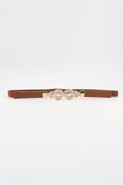 Slim brown PU leather belt with a sleek 0.6-inch silhouette and ornate zinc alloy buckle featuring rounded interlocking details.