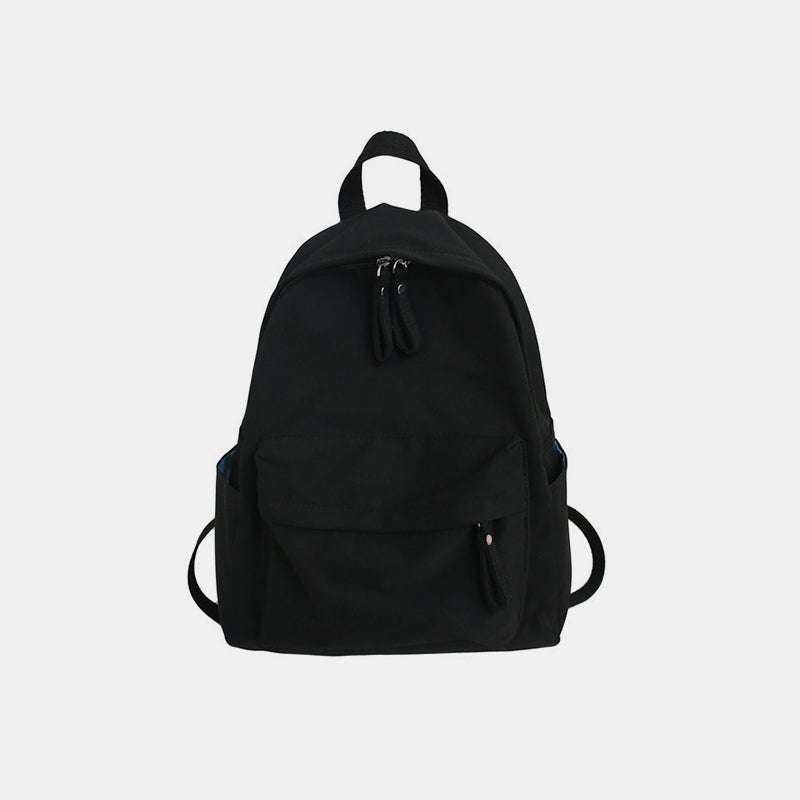 A large black cotton backpack with a streamlined silhouette, zip-top opening, front zip pocket, side pockets, adjustable straps, and a top handle.
