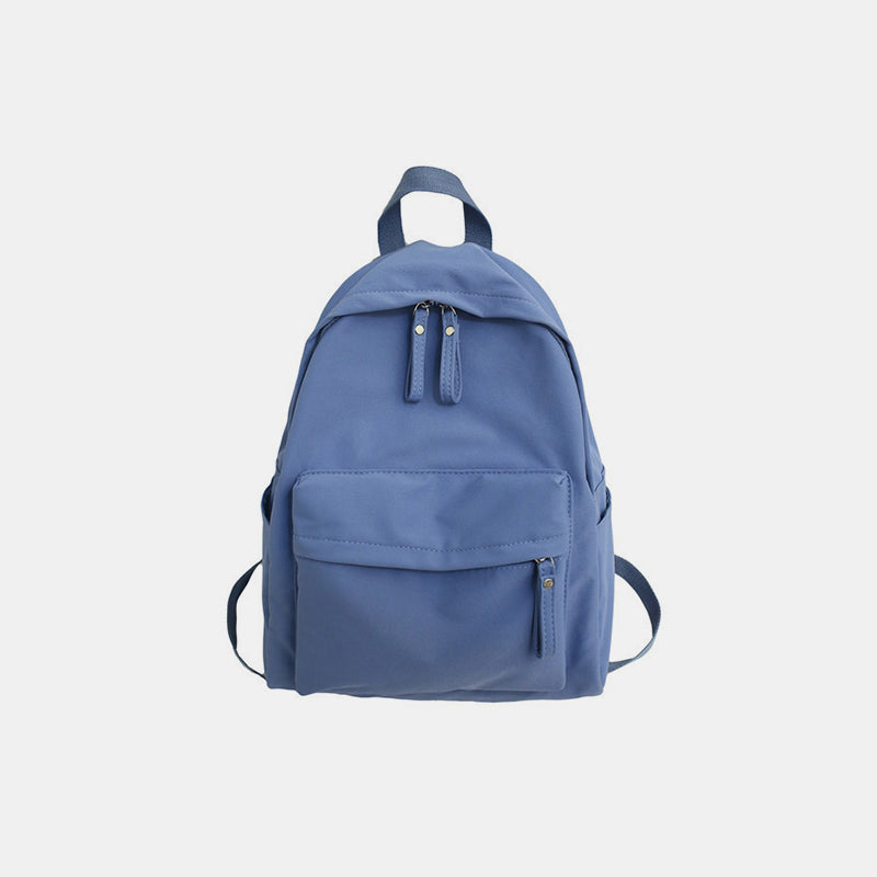 Blue cotton backpack with a streamlined silhouette, zip-top closure, roomy front zip pocket, adjustable shoulder straps, and a convenient top handle.