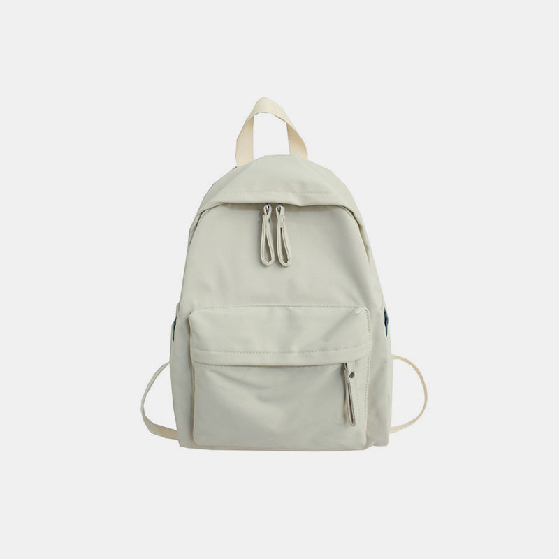 A large light cream cotton backpack with a streamlined silhouette, zip-top opening, roomy front zip pocket, top handle, and adjustable shoulder straps.