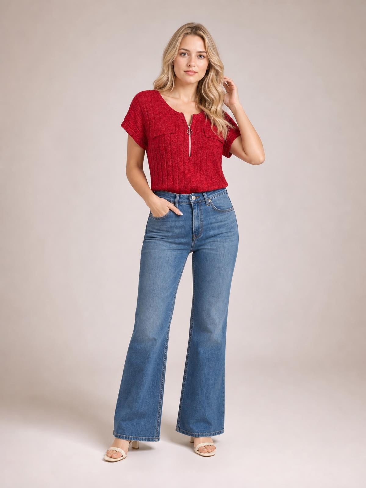 Model wearing a red ribbed short-sleeve T-shirt with a front zipper and fitted silhouette, posing with one hand in her jeans pocket.