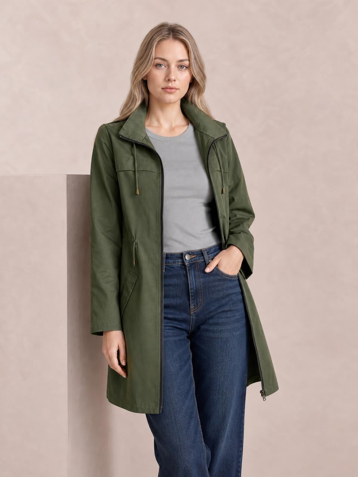 Model wears an olive green zip-up drawstring-waist hooded jacket with a longline regular-fit silhouette, visible zip pockets, and one hand in a pocket.