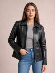 Model wearing a black zip-up leather jacket with a collared silhouette, long sleeves, seam detailing, and front pockets, posed with one hand in her jeans pocket.