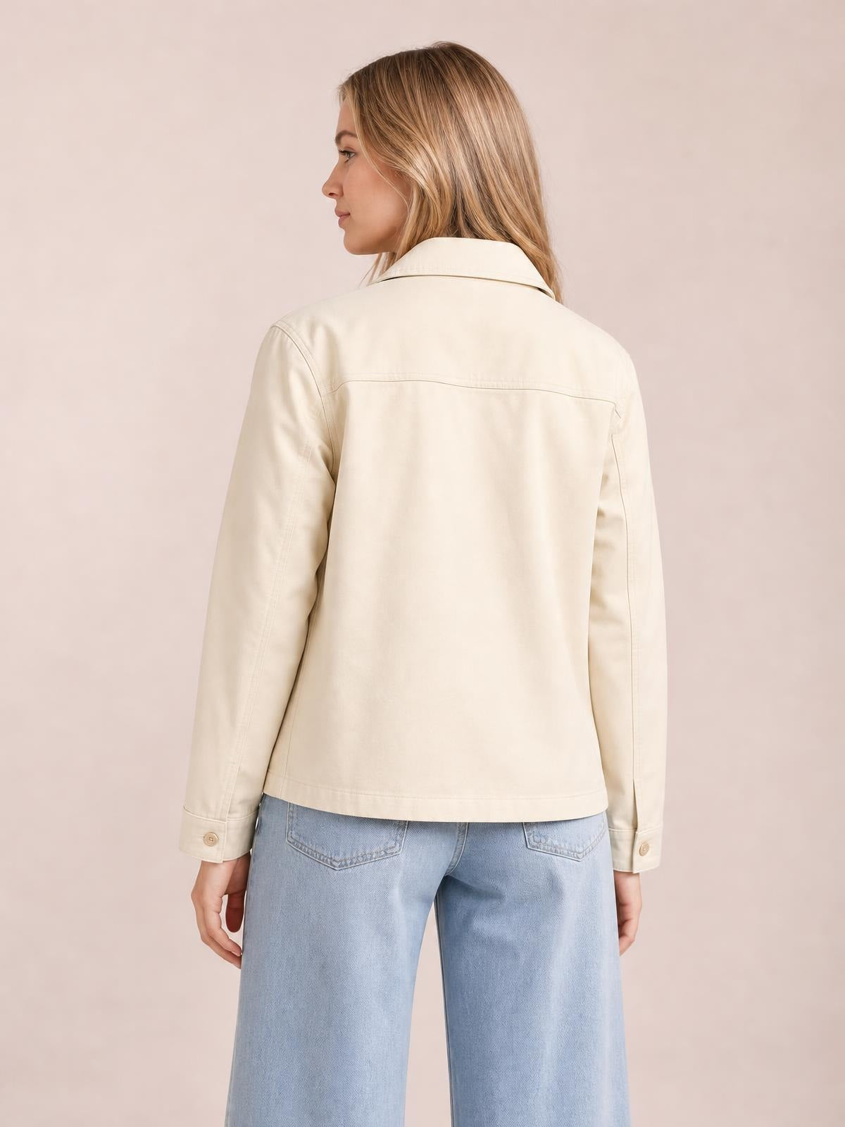 Model shown from the back wears a cream zip-up leather jacket with a pointed collar, long sleeves, buttoned cuffs, and a relaxed straight silhouette.