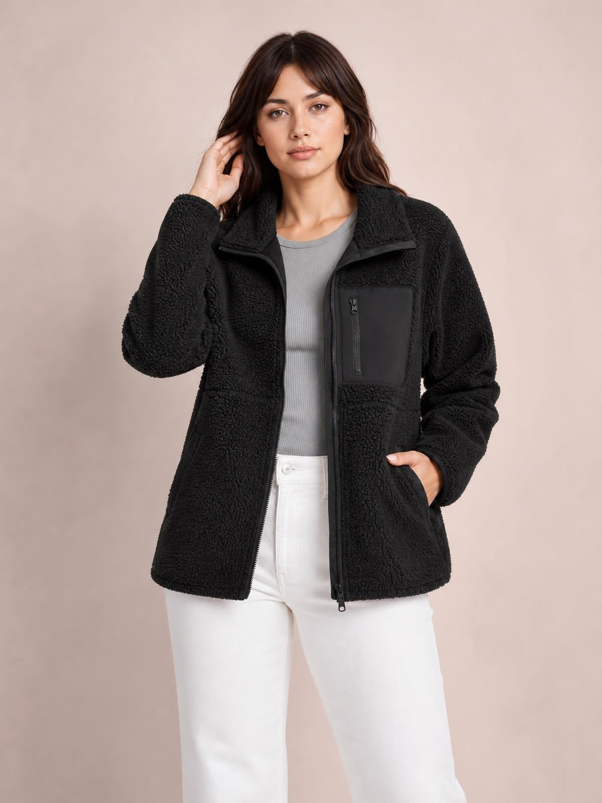Model wearing a black zip-up long sleeve plush jacket with a relaxed silhouette, textured fleece construction, collar, and multiple pockets.
